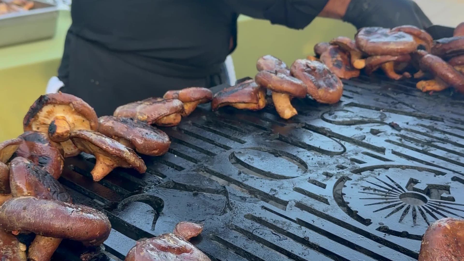 Skewers of tandoori kebabs and tikka grilling over open flame at an Ashoka live station