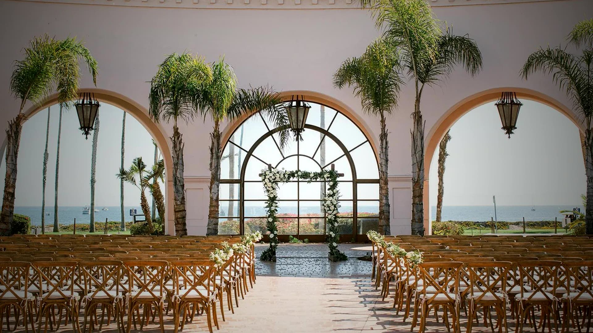 An arched, light-filled venue set for an Indian wedding
